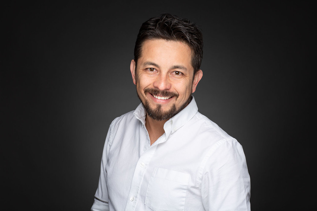 Headshot with a dark studio background